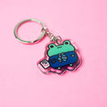 Keychain with a cartoon frog design on a pink background