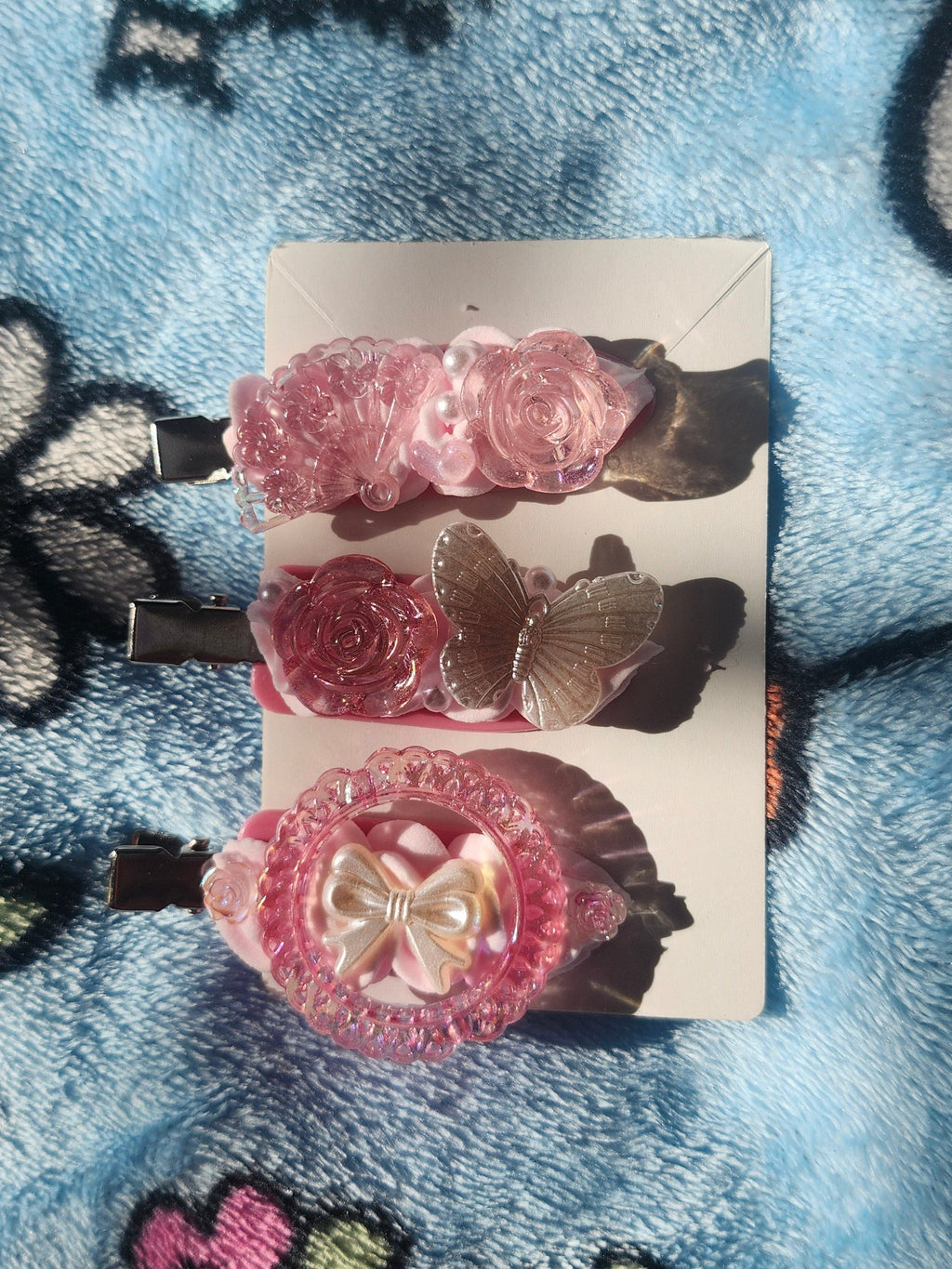 Pink Decoden Hair Clips on a card with a colorful, patterned background