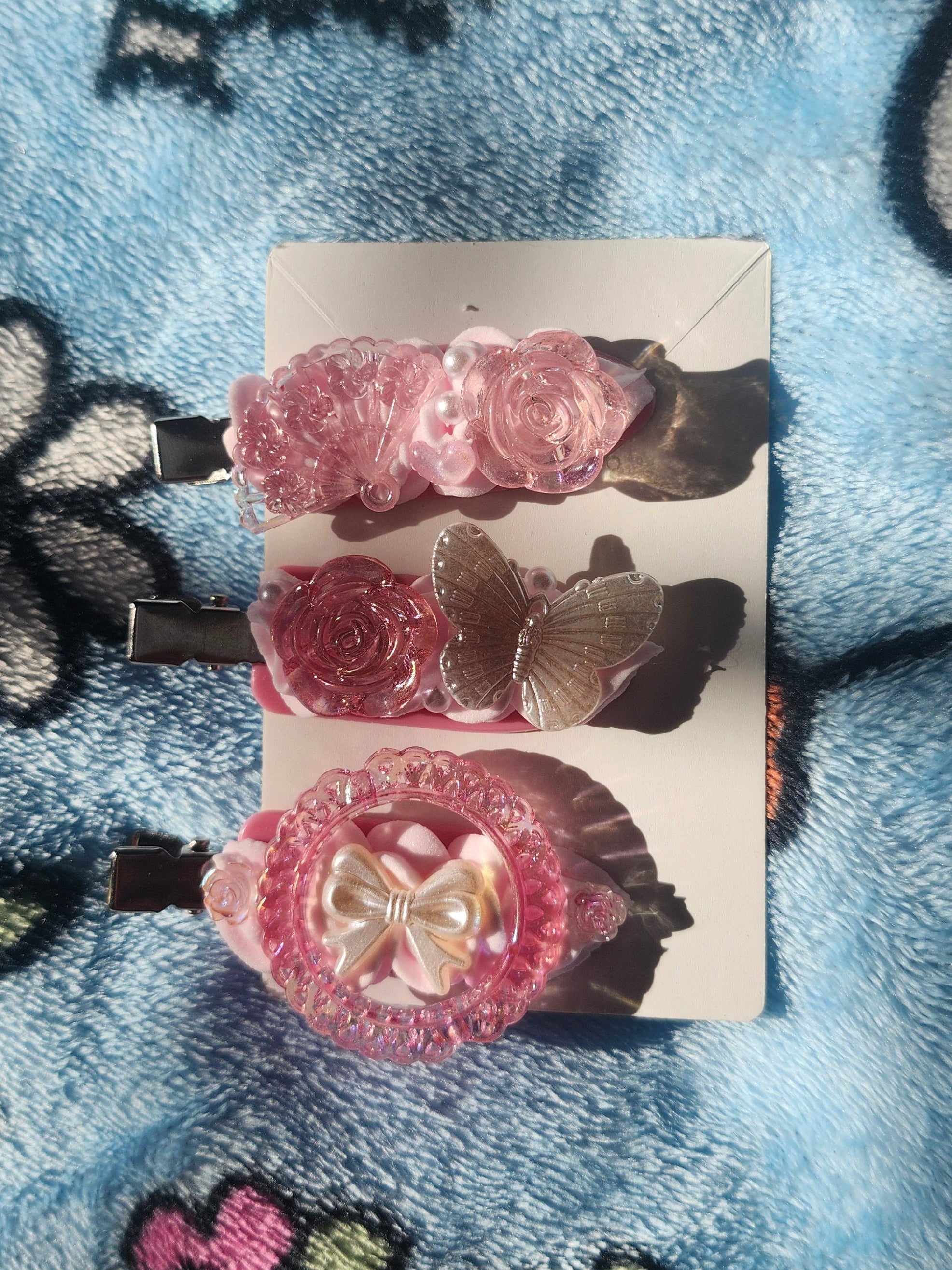 Pink Decoden Hair Clips on a card with a colorful, patterned background
