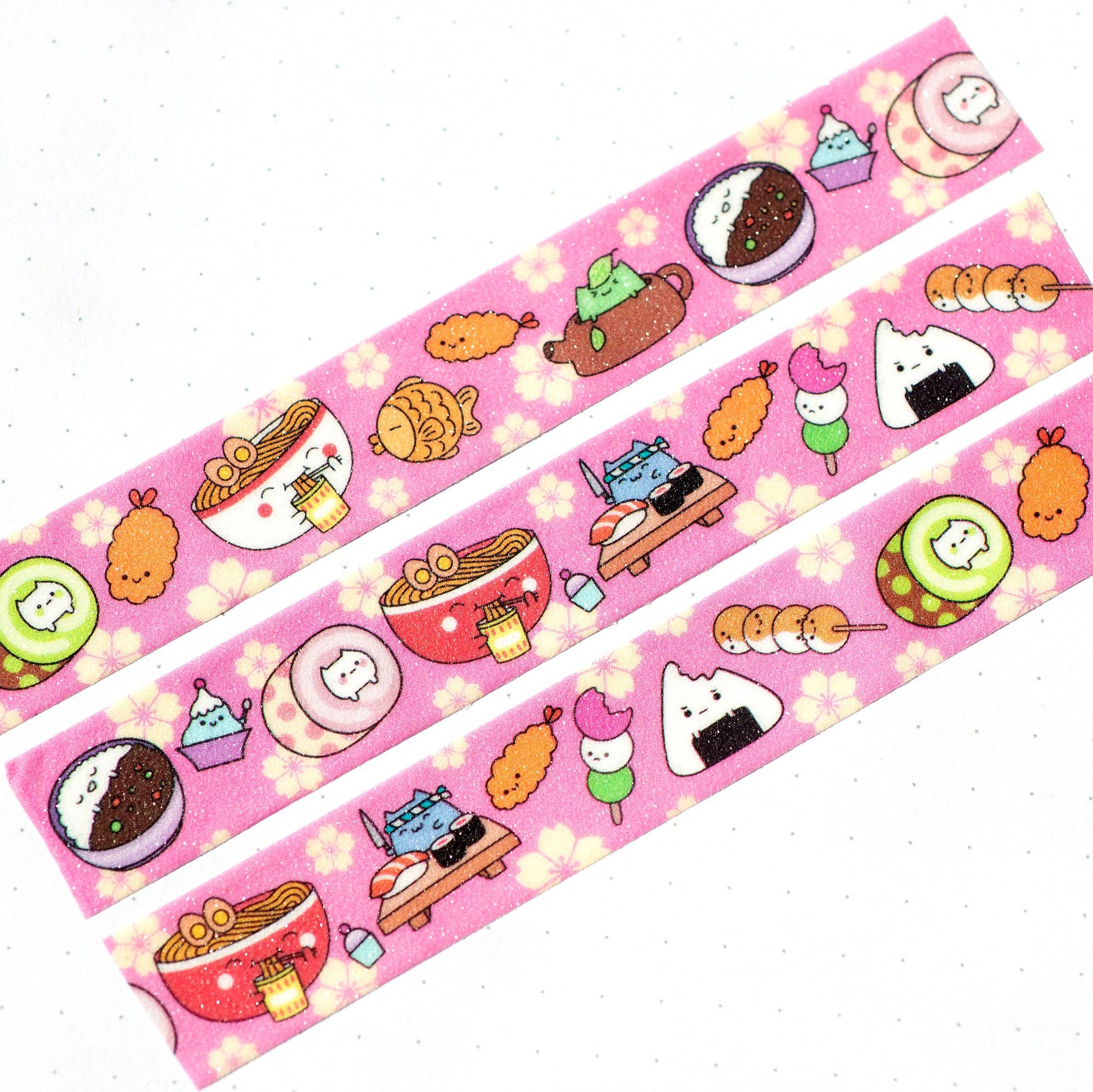 Three pink strips of washi tape with cute food illustrations on a white background