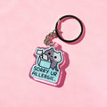 Keychain with a cat design and 'Sorry Ur Allergic' text on a pink background