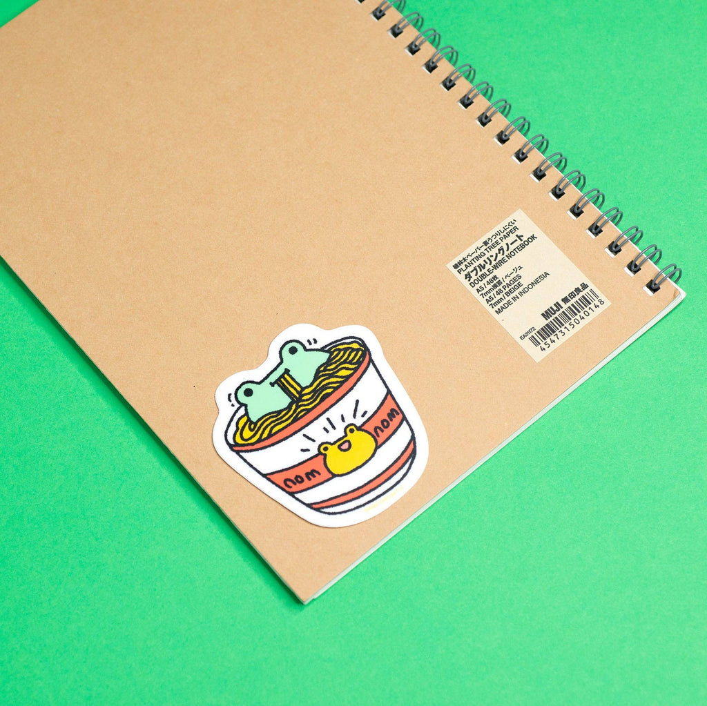 Notebook with a sticker of a cup of noodles on a green background